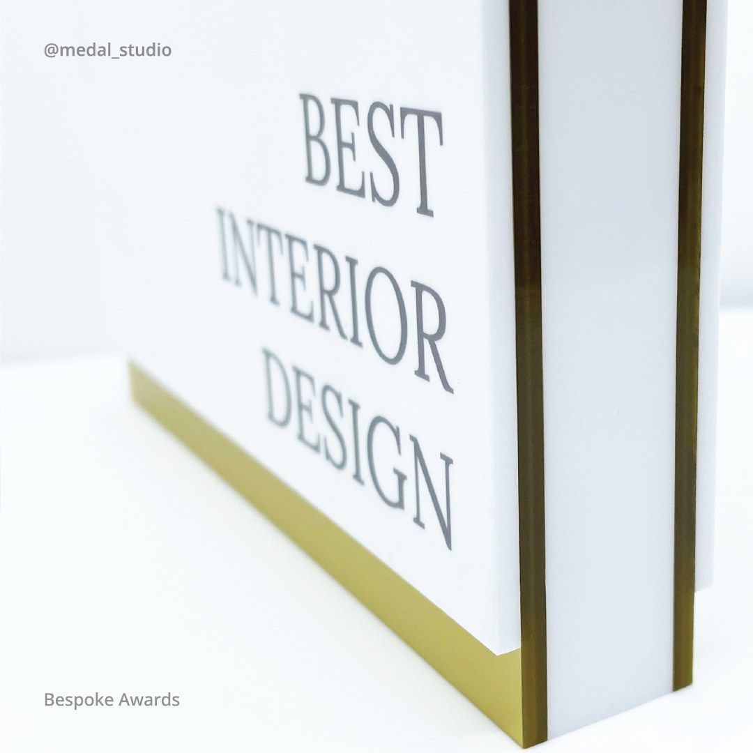 Close-up of a bespoke acrylic award with a printed face reading Best Interior Design
