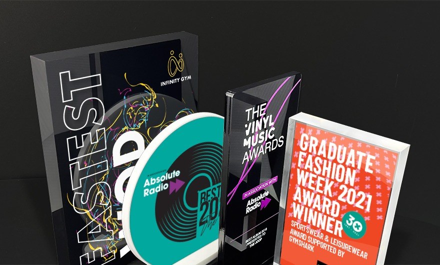 Four personalised acrylic awards side by side showing different printed designs and finishes