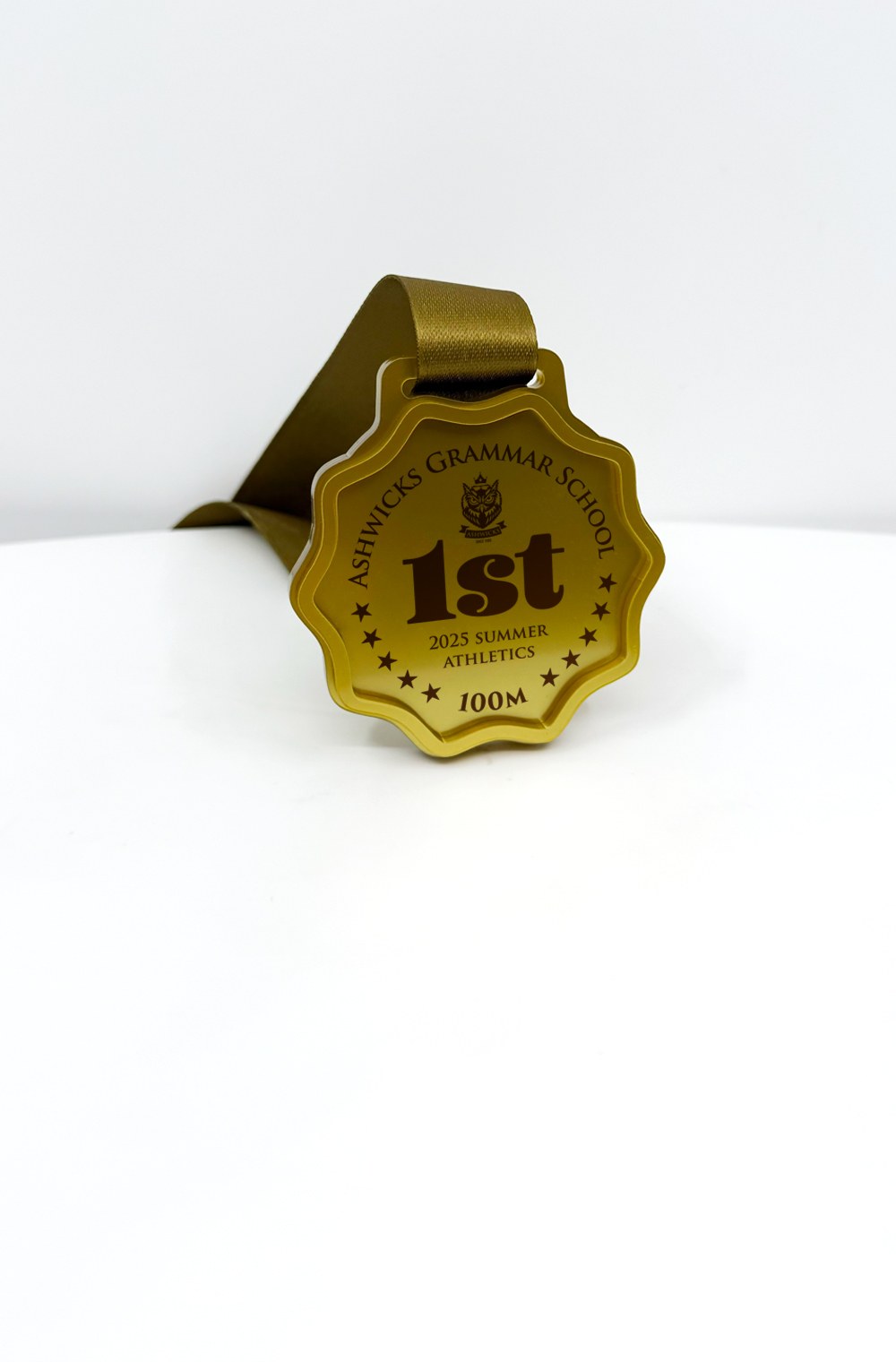 A custom shaped school medal printed with the school name and year